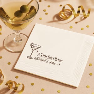 Celebrate in style with personalized 40th birthday napkins featuring A Tini Bit Older martini glass illustration. Custom printed with your name and milestone age on high quality white napkins, sold in sets of 50. Perfect for cocktail parties, martini themed birthdays, and chic events.