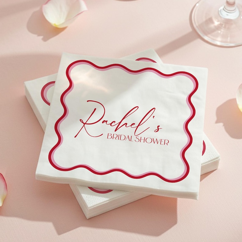 Elegant personalized bridal shower napkins with red scalloped border and custom name. White 3-ply paper cocktail napkins, perfect for wedding showers, rehearsal dinners, or engagement parties, adding a chic and functional detail to your table décor.