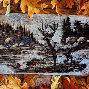 May include: A wooden plaque with a carved relief depicting a stag standing by water, with a forest in the background. The artwork is framed by autumn leaves, creating a seasonal theme.