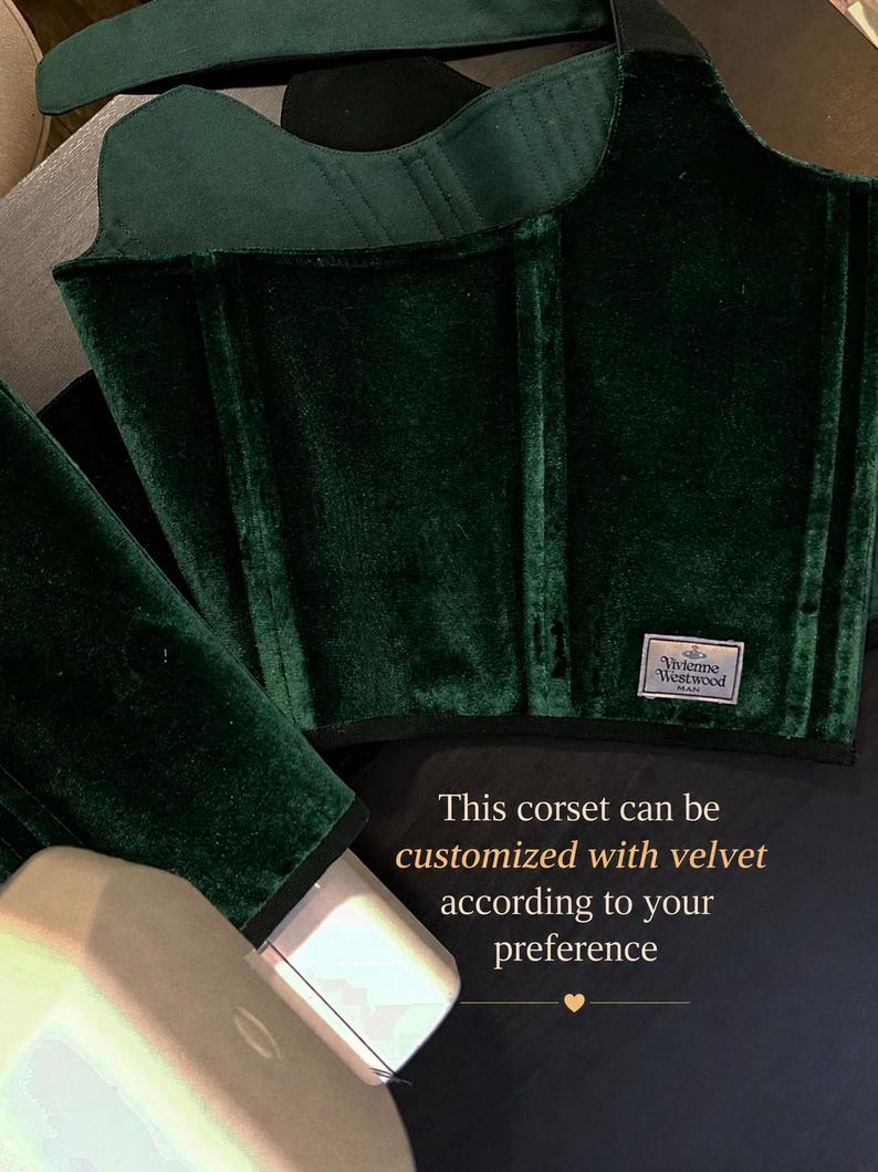 May include: A dark green velvet corset featuring vertical boning channels and a rectangular Vivienne Westwood MAN brand label. The garment includes text stating: This corset can be customized with velvet according to your preference.
