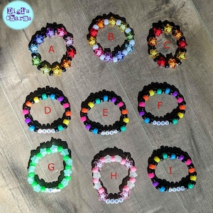 Könnte beinhalten: Neun bunte Perlenarmbänder mit sternförmigen Anhängern. Jedes Armband trägt ein anderes Jahr, von 1996 bis 2010.