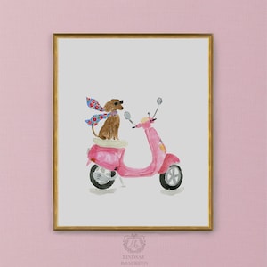 May include: A framed watercolor illustration featuring a brown dog wearing black sunglasses and a blue floral scarf, sitting on a bright pink motor scooter. The artwork is set against a light gray background and enclosed in a gold-colored frame.