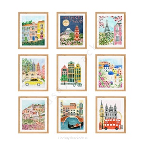 May include: A collection of nine framed watercolor art prints depicting various global cityscapes and landmarks, including scenes of Paris, London, New York, Venice, Santorini, and Japan, all presented in light wood frames arranged in a grid.