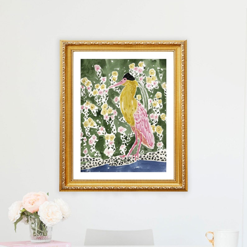 May include: A framed watercolor print featuring a stylized bird with yellow and pink plumage, set against a backdrop of green foliage and yellow flowers. The artwork is enclosed in a gold ornate frame, adding a touch of elegance to the botanical theme.