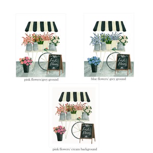 May include: A flower cart with a black and white striped awning, a wheel, and a chalkboard sign that says "Fresh Flowers". The cart is filled with pink flowers and there are pink flowers in a bucket on the ground. The background is grey.