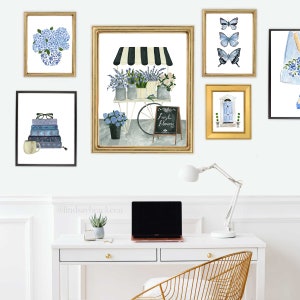 May include: A white desk with a gold chair and a laptop computer. There are five framed pictures on the wall above the desk. The pictures are of flowers, butterflies, a door, and books. The text on the sign in the picture reads "Fresh Flowers".