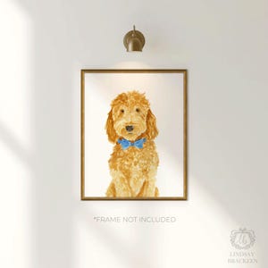 May include: A framed watercolor print of a golden-colored doodle dog with curly fur, wearing a bright blue bow tie around its neck. The artwork is centered within a gold-toned frame and features the text "FRAME NOT INCLUDED" at the bottom.
