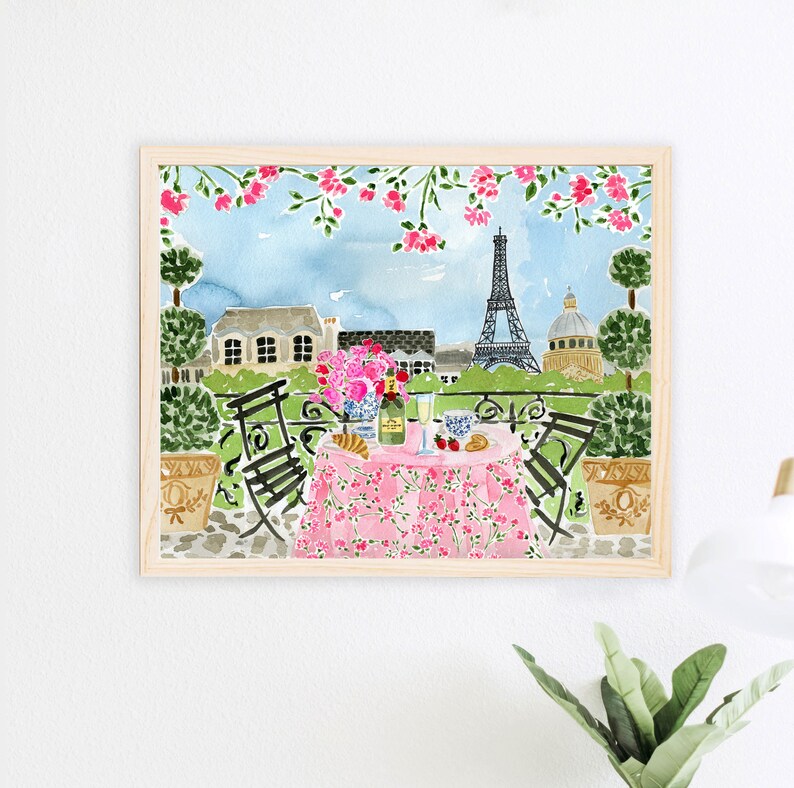 May include: Watercolor painting of a Parisian balcony scene with a pink tablecloth, two chairs, a bottle of champagne, and a view of the Eiffel Tower. The balcony is decorated with pink flowers.