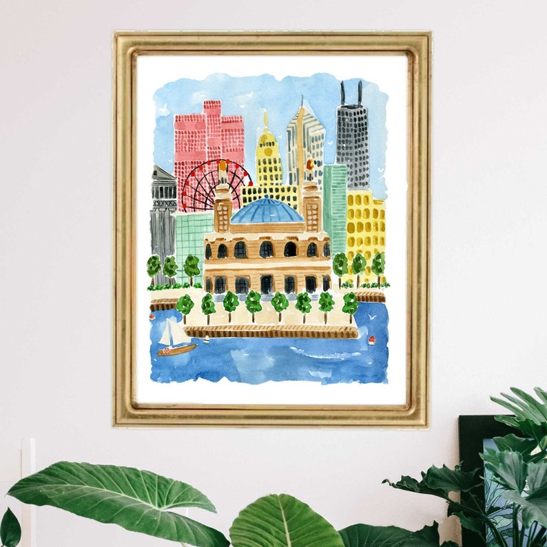 May include: A watercolor painting in a gold frame depicting a city skyline with a blue domed building in the foreground, a red ferris wheel, and various skyscrapers in shades of red, yellow, and grey, all situated along a blue body of water.