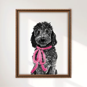 May include: A framed watercolor painting of a black curly-haired dog with a bright pink ribbon tied around its neck. The dog is depicted in a front-facing portrait style, set within a textured, metallic-toned rectangular frame with ornate edges.