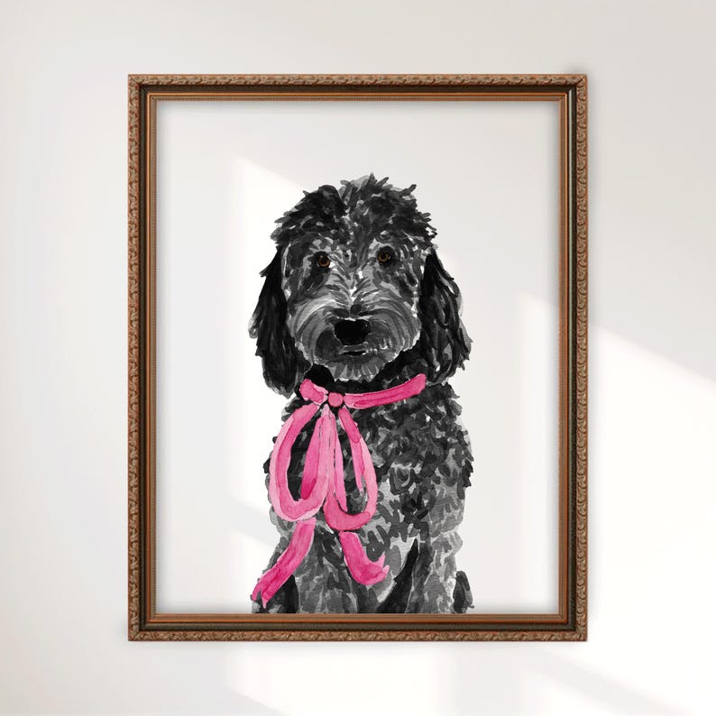 May include: A framed watercolor painting of a black curly-haired dog with a bright pink ribbon tied around its neck. The dog is depicted in a front-facing portrait style, set within a textured, metallic-toned rectangular frame with ornate edges.