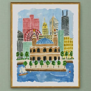 May include: A framed watercolor painting of a city skyline featuring a large domed building in the foreground, a red ferris wheel, and various skyscrapers. A small sailboat floats on blue water in the lower section. The artist name Lindsay Brackeen is printed at the bottom.