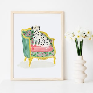 May include: A black and white Dalmatian dog sits on a green and gold floral patterned armchair with a pink cushion. The chair has ornate details and is set against a white background.