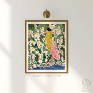 May include: A framed watercolor print featuring a stylized bird with yellow and pink plumage, set against a backdrop of green foliage and yellow and pink flowers. The artwork is in a gold frame and includes the text "*FRAME NOT INCLUDED".