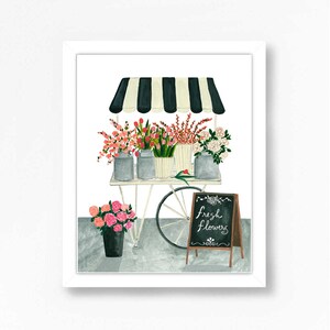 May include: A white flower cart with a black and white striped awning, filled with pink, white, and red flowers. The cart has a chalkboard sign that reads "fresh flowers".