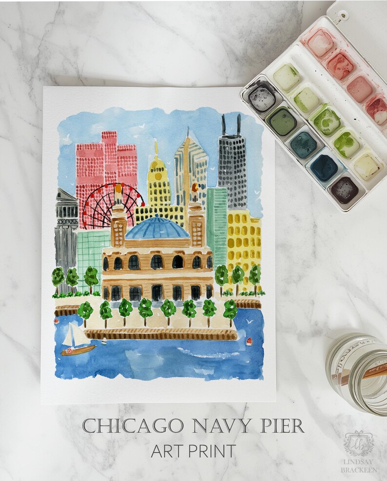 May include: A watercolor art print of the Chicago skyline featuring Navy Pier, a Ferris wheel, and various buildings in shades of pink, yellow, and blue. The print includes the text CHICAGO NAVY PIER ART PRINT at the bottom, with a paint set nearby.