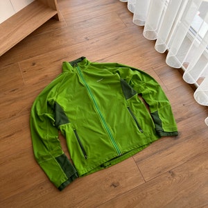Peut inclure: Une veste zippée verte et vert foncé avec un logo sur la poitrine gauche.