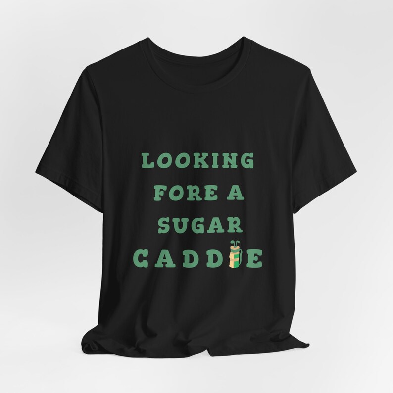 May include: Black t-shirt with green text that reads "Looking Fore A Sugar Caddie" with a green and brown golf bag icon.