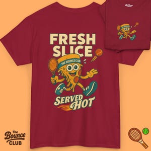 Puede incluir: Camiseta granate con una porción de pizza de dibujos animados jugando al tenis. La camiseta presenta el texto "FRESH SLICE SERVED HOT" y "The Bounce Club". Una versión más pequeña del diseño está en la parte superior derecha. Una raqueta y una pelota de tenis están en la parte inferior.