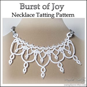 May include: A white tatting necklace with a delicate, lacy design. The necklace features a scalloped edge with small, sparkling embellishments. The text "Burst of Joy Necklace Tatting Pattern" is displayed at the top.