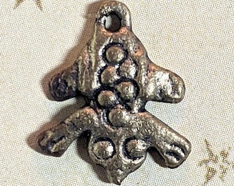 May include: A silver-toned metal charm in the shape of a stylized tree with a textured surface. The charm has a loop at the top for attaching to a necklace or bracelet.