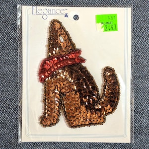 May include: A sequined wolf applique in shades of brown and copper, with a red scarf. The applique is on a white card with the word "Elegance" and a price tag. The Etsy shop name "seriousbeader.etsy.com" is at the bottom.