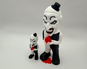 May include: Two white and black clown figurines with menacing expressions. The larger figure holds a red ball, with a red puddle at its feet. The smaller figure also holds a red ball. Both figures wear black top hats and outfits.
