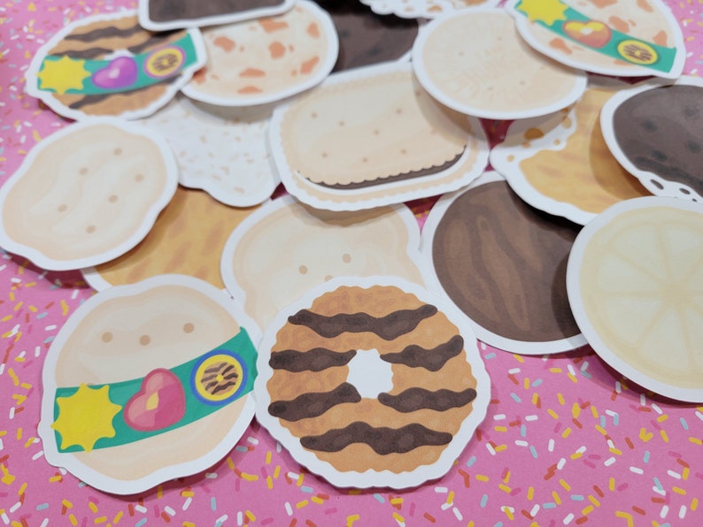 Może przedstawiać: Zbi&oacute;r kolorowych, ilustrowanych naklejek z ciasteczkami Girl Scout. Naklejki przedstawiają r&oacute;żne wzory ciasteczek, w tym Thin Mints, Samoas, Tagalongs i Do-si-dos.