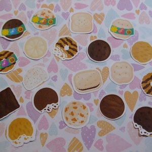 Pu&ograve; includere: Una collezione di adesivi colorati di biscotti Girl Scout su uno sfondo bianco con cuori rosa, viola e gialli. Gli adesivi presentano vari disegni di biscotti, tra cui Thin Mints, Samoas, Tagalongs e Do-si-dos.