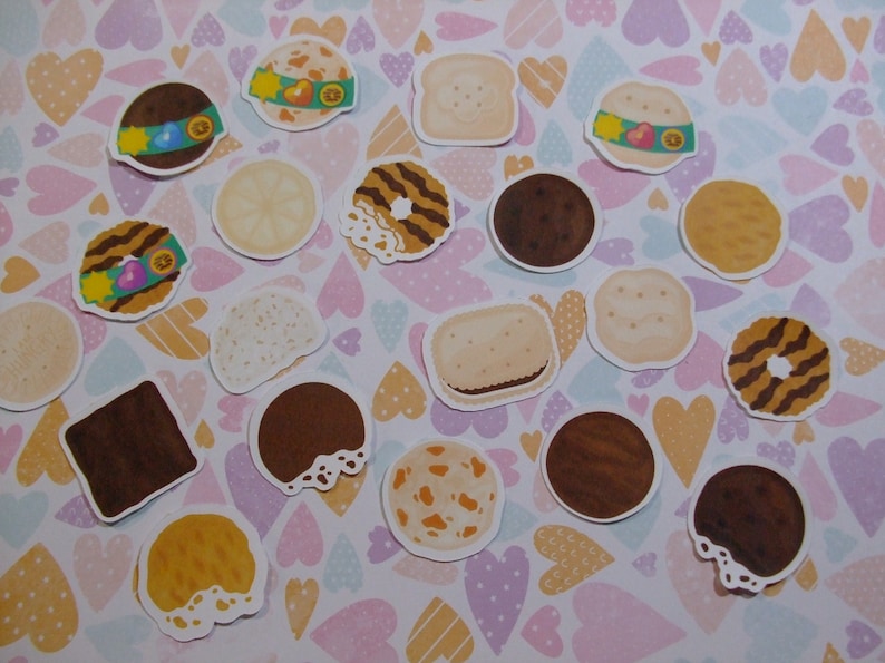 Pu&ograve; includere: Una collezione di adesivi colorati di biscotti Girl Scout su uno sfondo bianco con cuori rosa, viola e gialli. Gli adesivi presentano vari disegni di biscotti, tra cui Thin Mints, Samoas, Tagalongs e Do-si-dos.