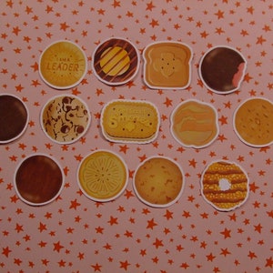 Op de afbeelding: Een verzameling van 12 Girl Scout cookie stickers, met verschillende smaken zoals Thin Mints, Samoas en Tagalongs. De stickers zijn gerangschikt op een roze achtergrond met oranje sterren.
