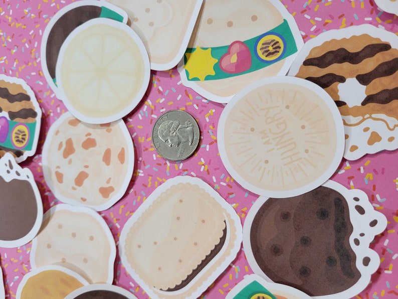 Może przedstawiać: Zbi&oacute;r kolorowych naklejek z r&oacute;żnymi wzorami ciasteczek Girl Scout, w tym Thin Mints, Samoas, Lemonades i Tagalongs. Naklejki są ułożone na r&oacute;żowym tle z białymi i ż&oacute;łtymi posypkami.
