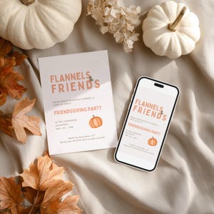May include: A Friendsgiving party invitation and a smartphone with the same design, reading "Flannels & Friends" with a pumpkin illustration. The scene includes white pumpkins and autumn leaves. The invitation is in a flat lay arrangement.