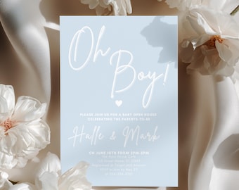 Könnte beinhalten: Eine hellblaue Babyparty-Einladung mit dem Schriftzug "Oh Boy!" in weißer Schrift. Die Einladung enthält die Namen "Halle & Mark" und Veranstaltungsdetails. Weiße Blumen und ein Satin-Stoffhintergrund vervollständigen das Design.