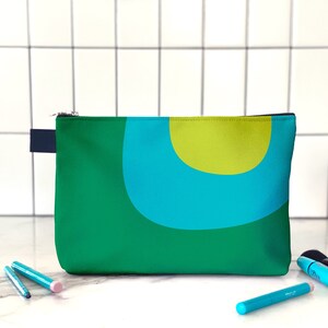 Retro cosmetics bag. A green and blue makeup bag with mid century, abstract print for cosmetics, toiletries, or accessories. Travel set