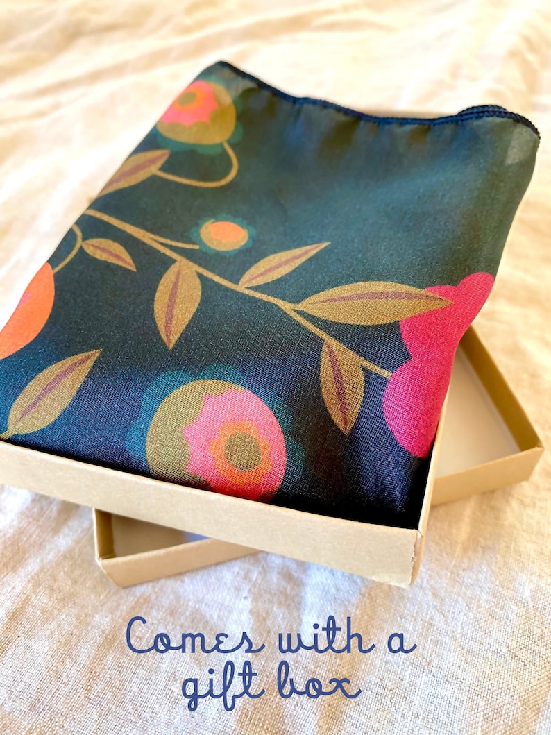 May include: A dark green silk scarf with a floral pattern in shades of pink, orange, and gold. The scarf is folded and placed in a brown gift box. "Comes with a gift box" is written in blue text on the bottom of the image.