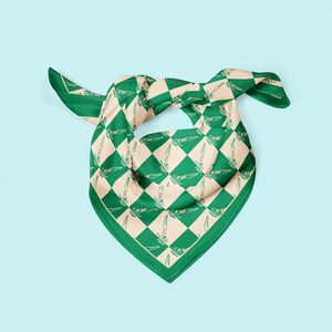 May include: A green and beige checkered bandana with a repeating pattern of stylised figures. The bandana is folded and tied in a knot.