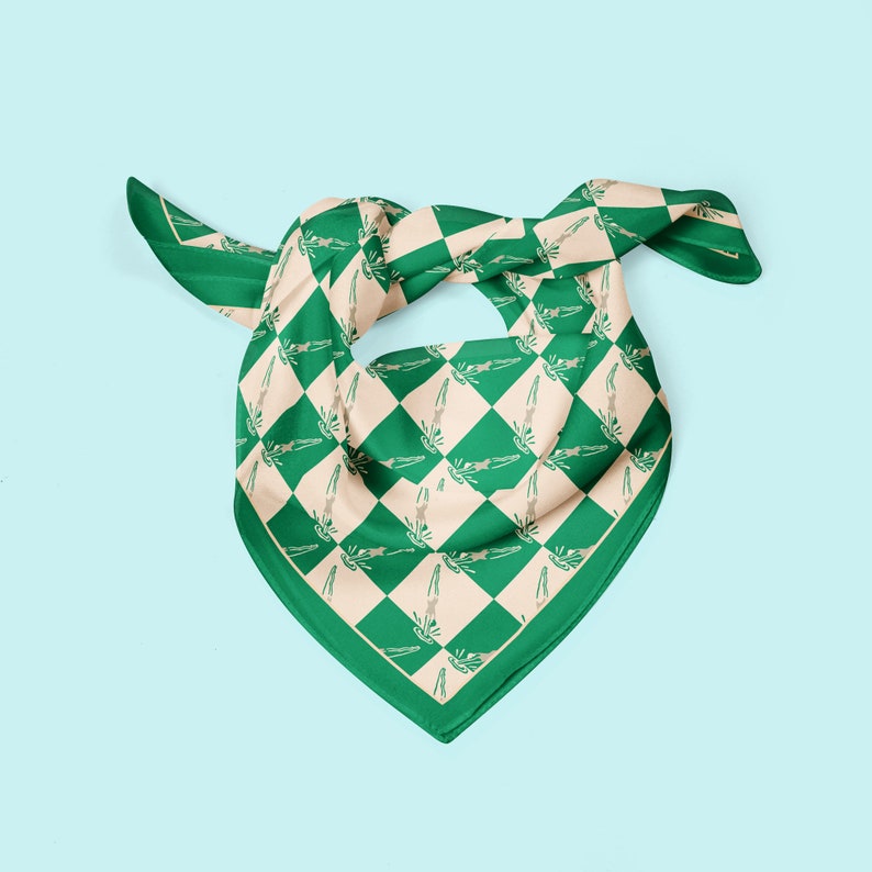 May include: A green and beige checkered bandana with a repeating pattern of stylised figures. The bandana is folded and tied in a knot.