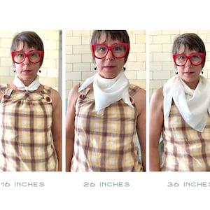 May include: Three images showing a person wearing a white square scarf tied in a knot at the neck. The scarf is shown in three different sizes: 16 inches, 26 inches, and 36 inches. The person is wearing a yellow and brown plaid shirt and red glasses.