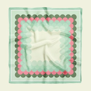 May include: A green and pink patterned square scarf with a white border. The pattern features a series of overlapping circles in shades of green and pink.
