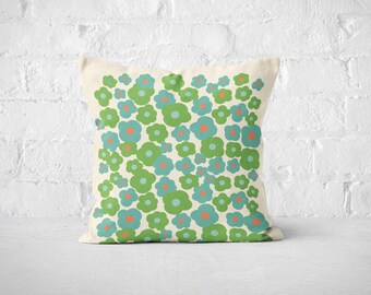 May include: A cream-colored throw pillow with a repeating pattern of green and blue flowers with orange centers.