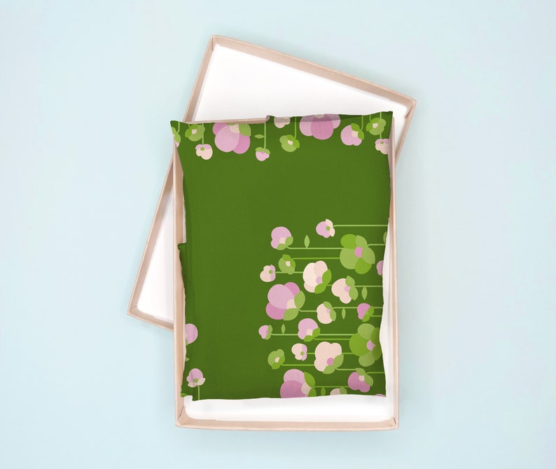 May include: A green pillowcase with a floral pattern of pink flowers and green leaves. The pillowcase is in a cardboard box.