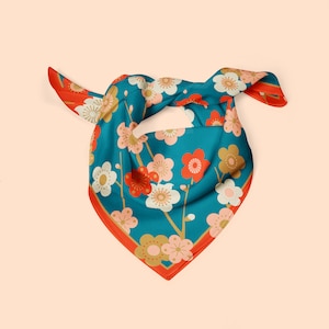 May include: A teal blue silk scarf with a floral pattern featuring red, white, and gold flowers. The scarf has a red border.