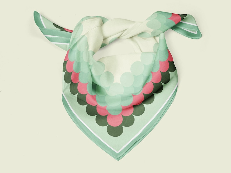 May include: A green silk scarf with a white border and a pattern of overlapping circles in shades of green, pink, and black.