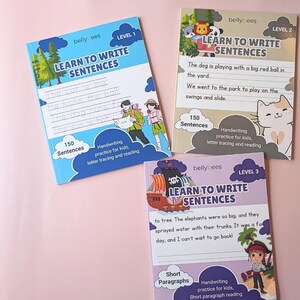 Puede incluir: Se muestran tres cuadernos infantiles coloridos titulados "Learn to Write Sentences". Cada libro presenta ilustraciones y el texto "150 Oraciones". Las portadas son azules, beige y moradas, con diferentes designaciones de nivel.