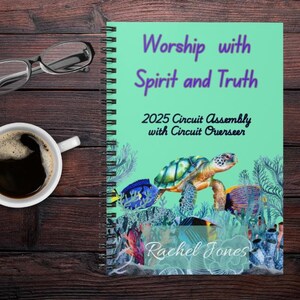 May include: A spiral-bound notebook with a teal cover featuring the text "Worship with Spirit and Truth" and "2025 Circuit Assembly with Circuit Overseer." The cover also displays a sea turtle and fish illustration. A cup of coffee and glasses are on a wooden surface.