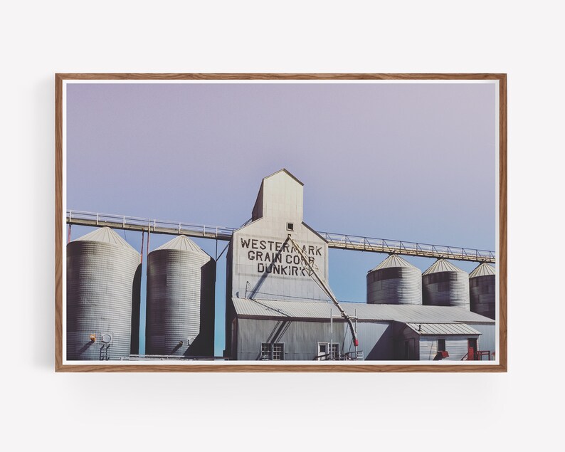 May include: A vintage photograph of a grain elevator with the text "Westernark Grain Corp. Dunkirk" on the side. The building is made of metal and has a series of silos.