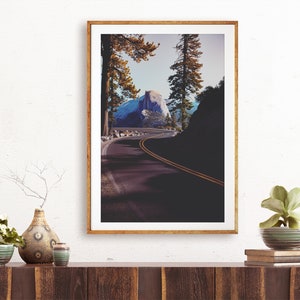 Pu&ograve; includere: Una fotografia incorniciata di una strada tortuosa che conduce a una cima di montagna nel Parco Nazionale di Yosemite. La strada &egrave; fiancheggiata da alberi e la montagna &egrave; visibile in lontananza. La fotografia &egrave; in una cornice di legno.