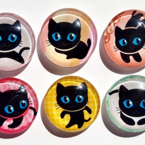 May include: Six round glass cabochons with black cat illustrations on different colored backgrounds. The backgrounds include white, yellow, pink, green, orange, and red.