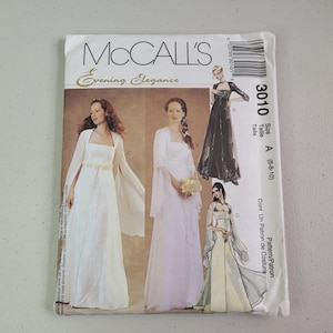 May include: A McCall's Evening Elegance sewing pattern envelope, number 3010, size A (6-8-10). The front displays four illustrations of floor-length gowns with long sleeves and various necklines, including white, light pink, and black options.